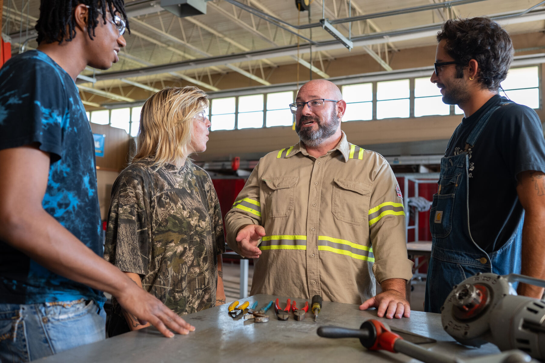 Brian Nathan talking with apprentices around a workbench at an IBEW training center